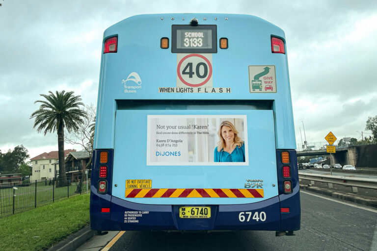 The back of a bus showing a real estate advert "Not your usual 'Karen'"